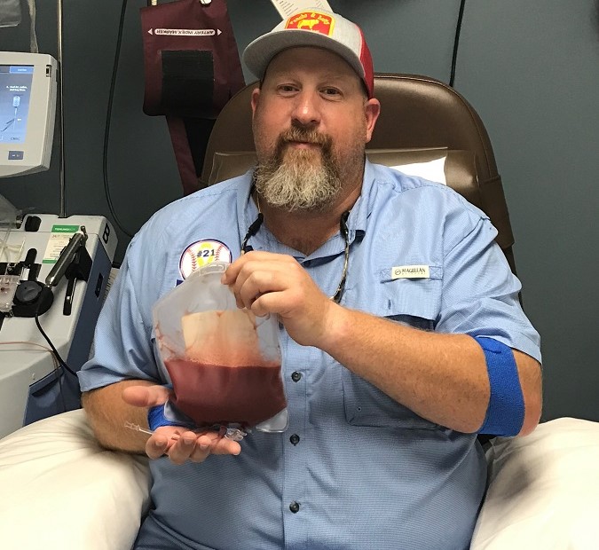 Jeremiah after donating, holding a bag of his blood stem cells